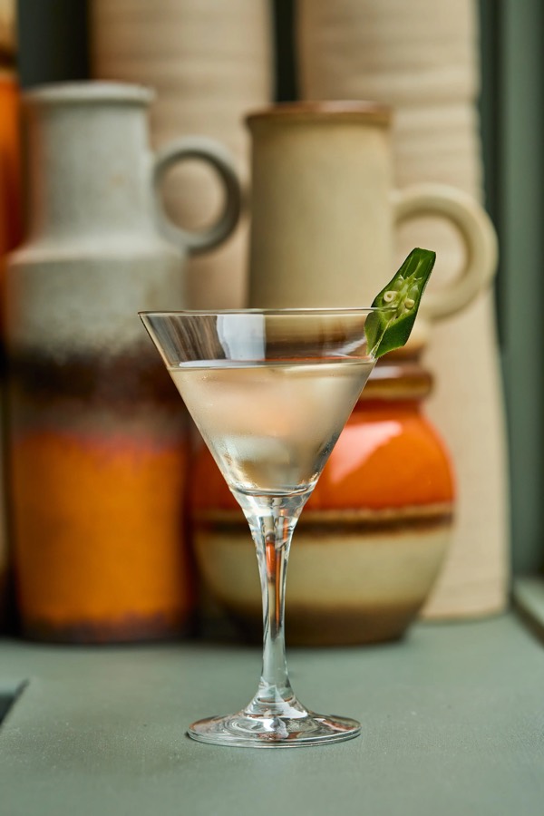 Martini cocktail with an okra garnish